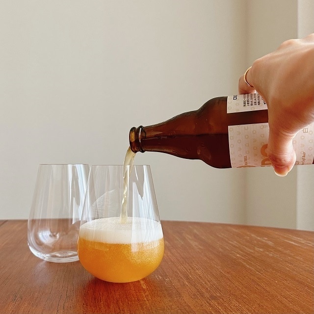 瓶ビールをステムレスグラスに注いでいる画像