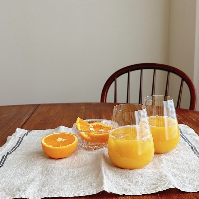 ステムレスグラスにオレンジジュースを注いだ様子