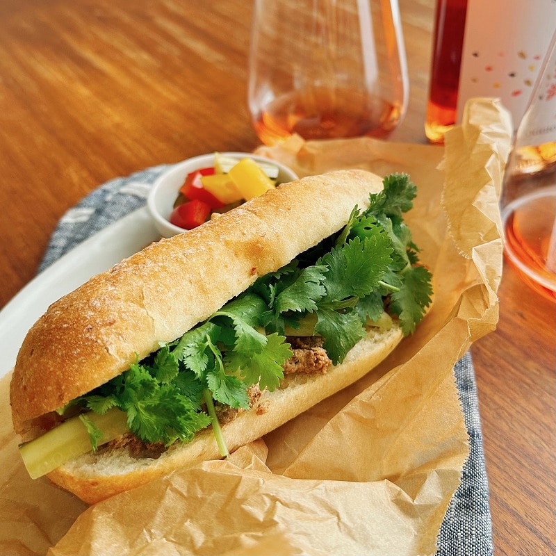 ベトナム風サンドイッチとロゼワインがテーブルに載っている